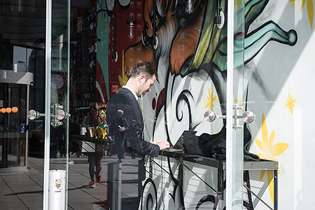 Man am Laptop vor Grafitti - Janet Große Fotografin Streetphotography