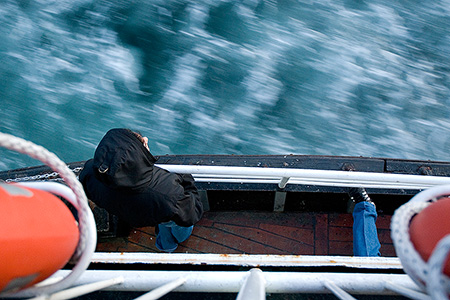 Mann auf Boot schaut in den Fluss - Janet Große Fotografin Streetphotography